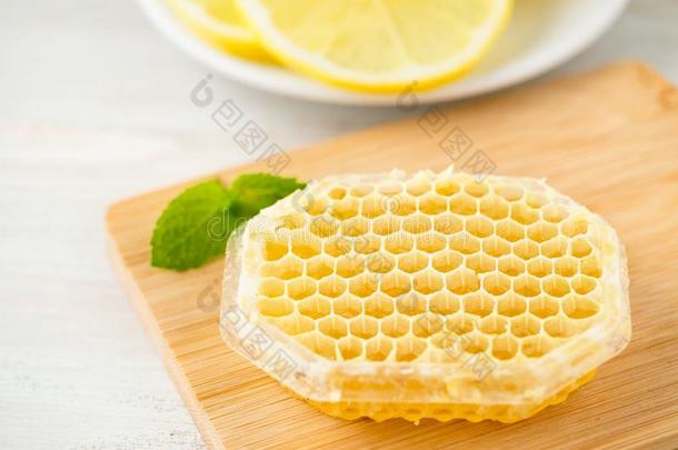 白色的杯子关于茶水,蜂蜜,蜂蜜comb,柠檬向白色的背景.英语字母表的第6个字母