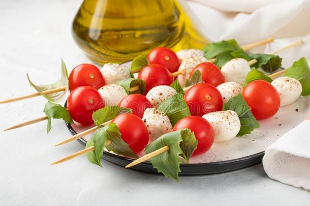 红白小碟沙拉-串肉杆和番茄,意大利干酪和罗勒属植物,意大利