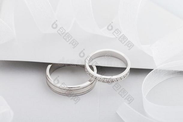 两个银婚礼戒指和菱形向灰色背景
