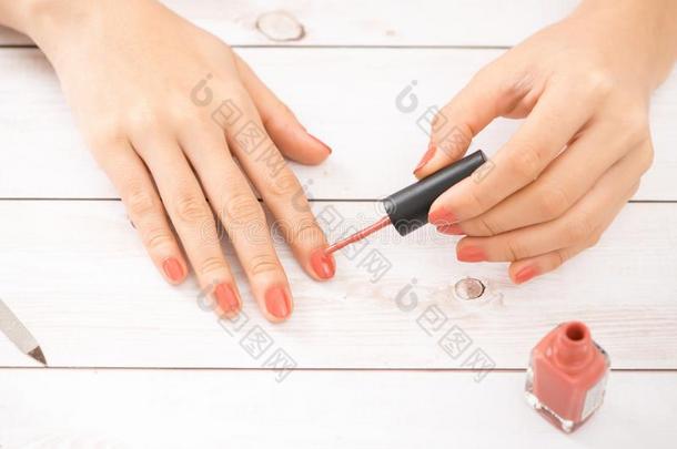 女人获得钉子修指甲.指甲修饰师应用红色的钉子擦光