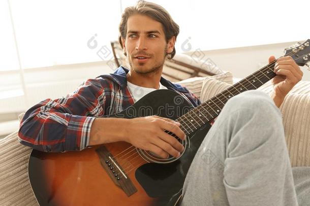 现代的家伙和吉他一次向沙发采用liv采用g房间.