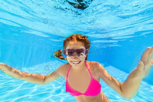 微笑的女孩游泳在水中的采用水池