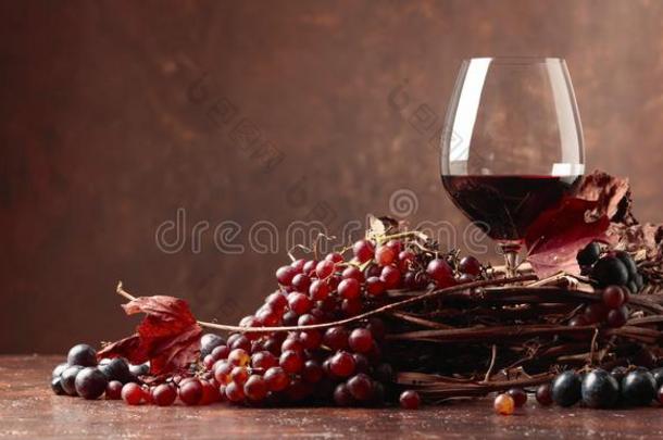 红色的葡萄酒和新鲜的葡萄和干燥的在上面藤树叶.