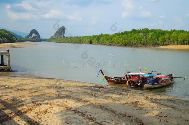 低的潮汐水洋和木制的观光小船和风景优美的泰国或高棉的佛教寺或僧院