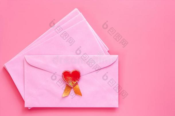 粉红色的信封和红色的心向粉红色的背景