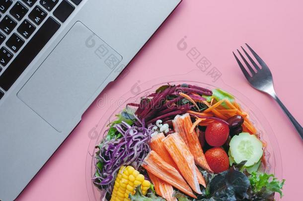 新鲜的沙拉蔬菜和计算机便携式电脑在工作场所