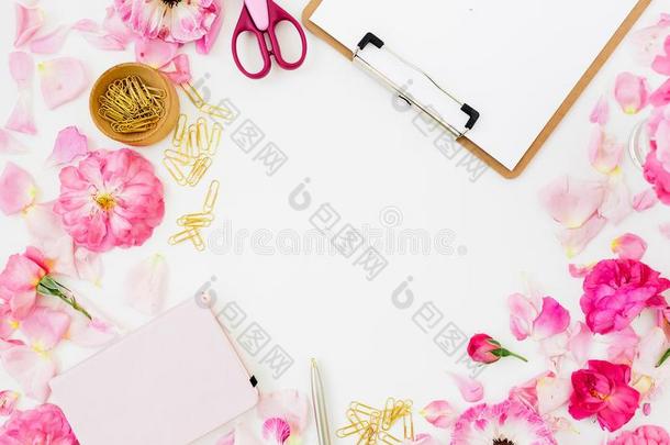 工作区和有纸夹的笔记板,彩色粉笔玫瑰和附件向白色的