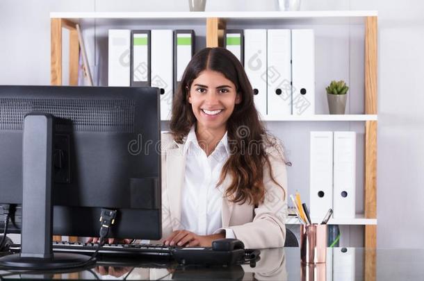微笑的女商人打字向键盘