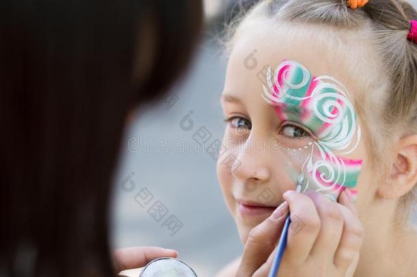小的女孩获得她面容描画的在旁边面容绘画艺术家.