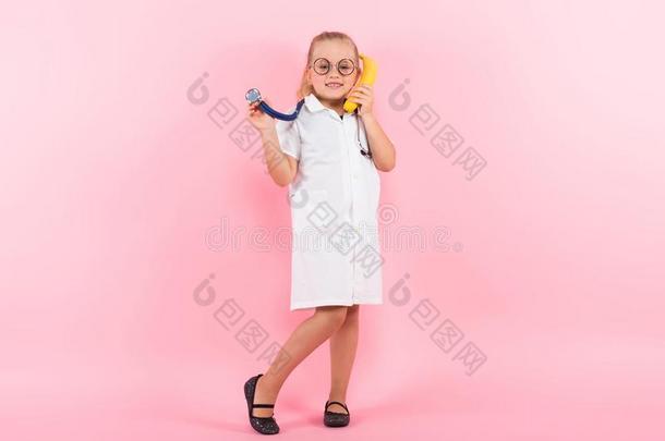 小的女孩采用医生戏装和香蕉