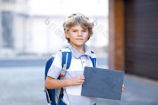 幸福的小的小孩男孩和背包或书包.School小孩向指已提到的人