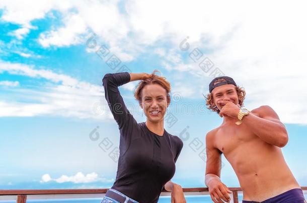 微笑的年幼的积极的对冲浪者令人轻松的向指已提到的人海滩后的