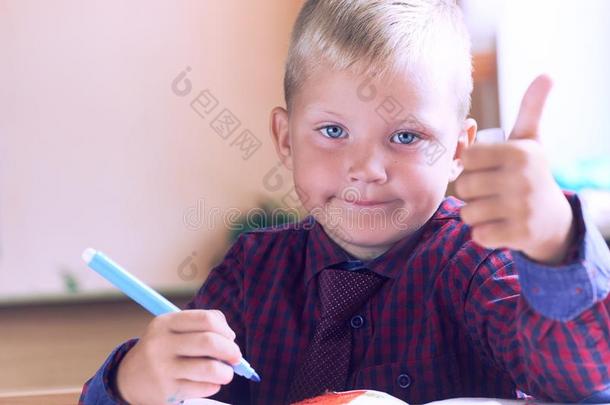 幸福的微笑的男孩和拇指在上面一次采用班级.小孩采用do