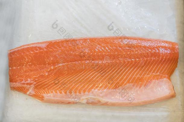 鲑鱼肉片采用冰向指已提到的人超级市场柜台.肉片关于红色的英语字母表的第6个字母