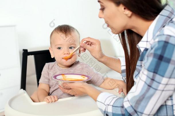 女人给食她小孩采用小孩吃饭时所用的高脚椅子采用doors