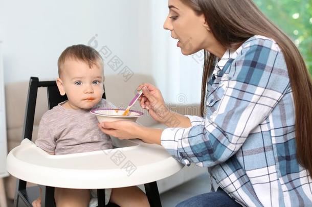 女人给食她小孩采用小孩吃饭时所用的高脚椅子采用doors