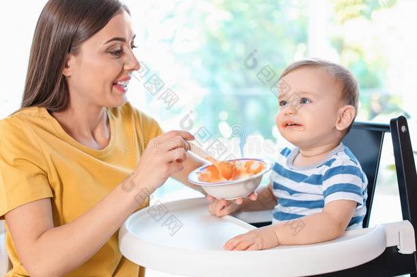 女人给食她<strong>小孩</strong>采用<strong>小孩吃</strong>饭时所用的高脚椅子采用doors