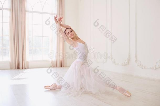 一芭蕾舞女演员采用白色的衣服采用一白色的工作室.