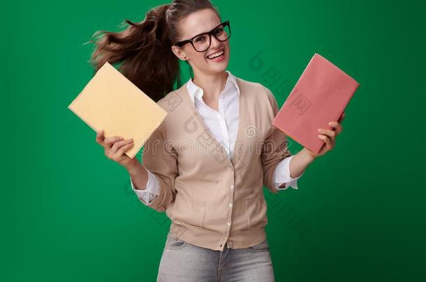 幸福的现代的学生女人和书反对绿色的背景