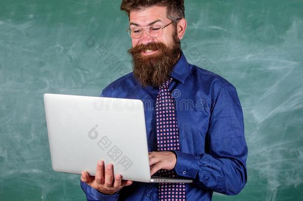 冲浪运动互联网.教师有胡须的男人和现代的便携式电脑冲浪运动