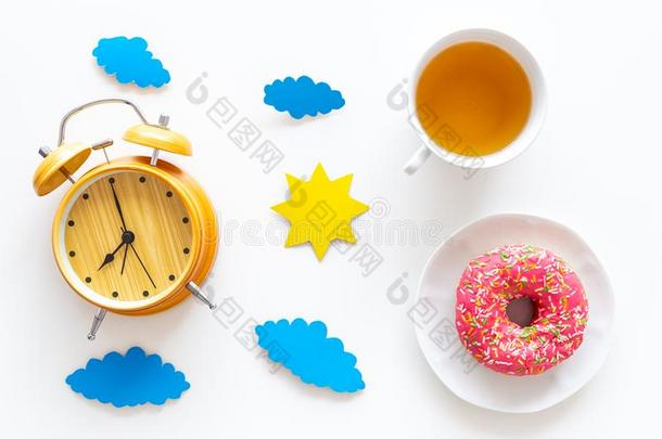 时间为早餐观念.茶水,油炸圈饼在近处惊恐钟,太阳和