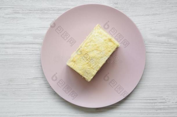 块关于旧法国金币蛋糕向粉红色的盘子越过白色的木制的后座