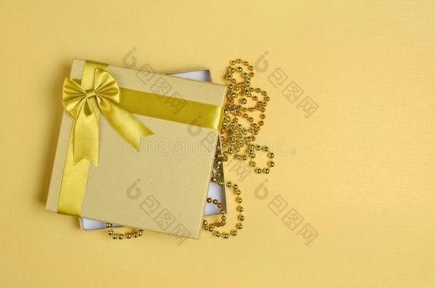 金色的发光的典型的赠品盒和缎弓和garl和关于有孔小珠