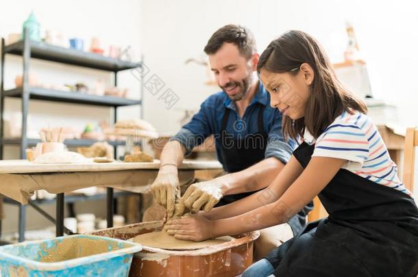 指导者帮助学生采用制造陶器