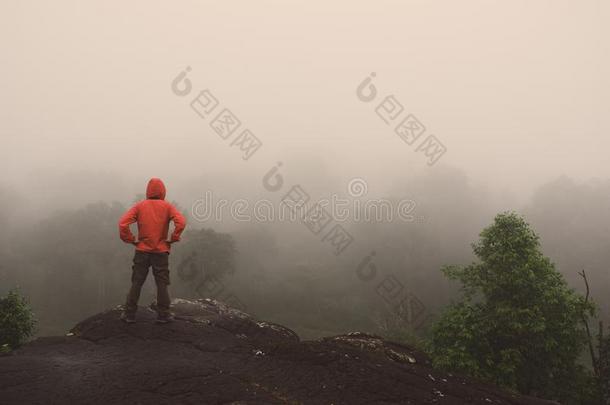 旅行支票男人凸起的手起立向悬崖山冒险活动