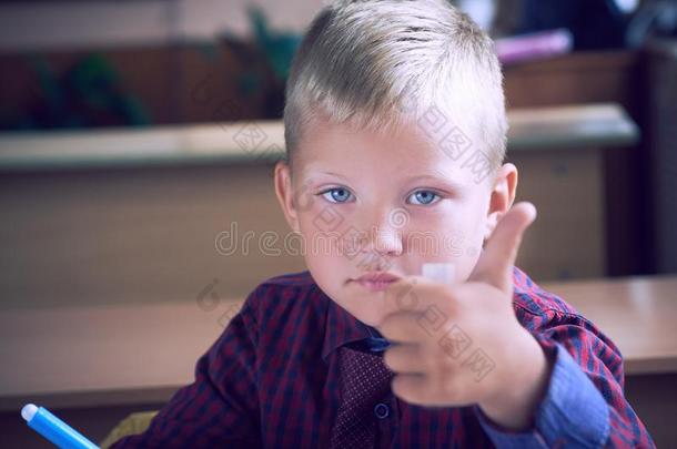 幸福的微笑的男孩和拇指在上面一次采用班级.小孩采用do