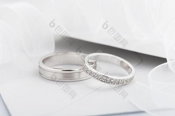 两个银婚礼戒指和菱形向灰色背景