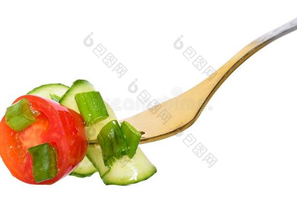 餐叉和沙拉蔬菜从番茄和黄瓜隔离的