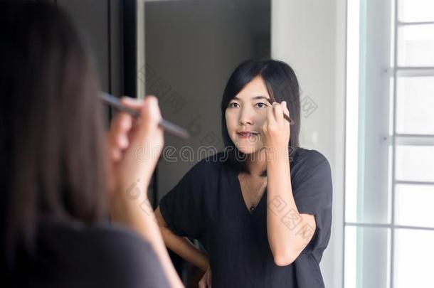 亚洲人女人<strong>改正</strong>眉毛形状和刷子,化妆和漂亮的东西或人
