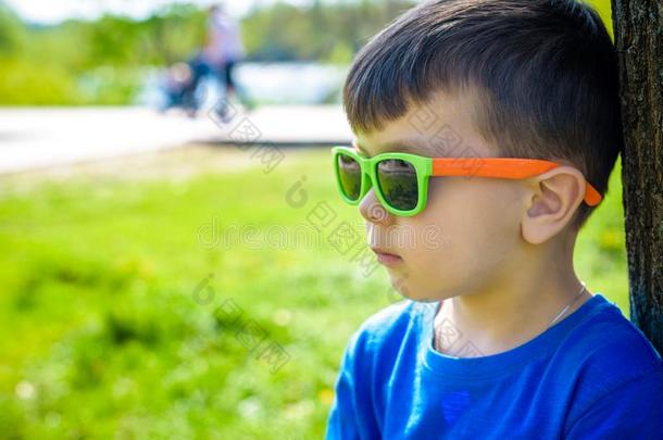 肖像关于聪明的小的男孩使人疲乏的太阳镜<strong>傻笑</strong>.