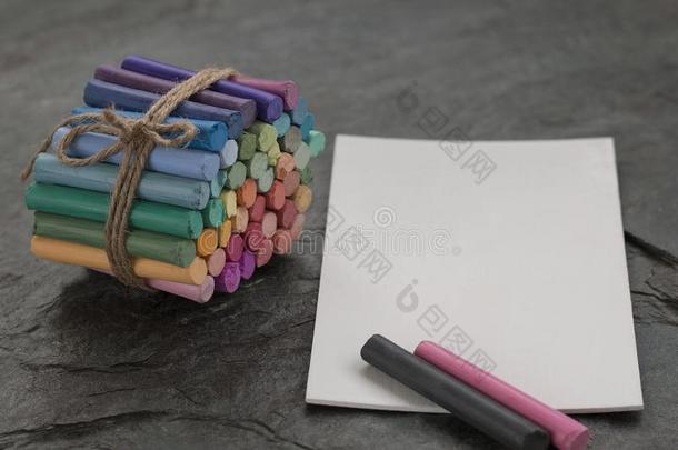 有色的彩色粉笔用彩色蜡笔画和白色的水彩纸向黑暗的st向e