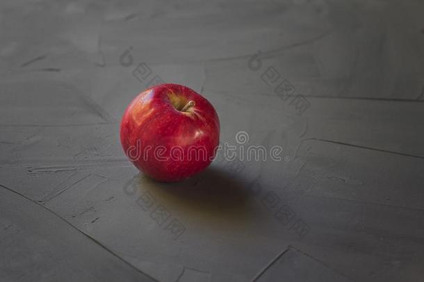 明亮的红色的苹果向灰色的和黑的背景