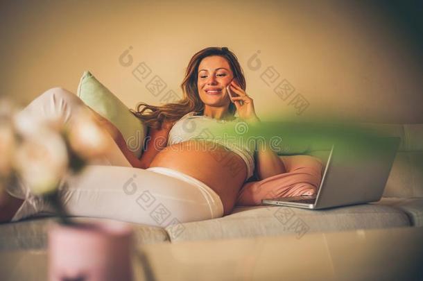 怀孕的女人工作的在家.使用科技.