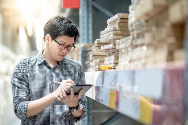 亚洲人男人做盘点在旁边使用碑采用仓库