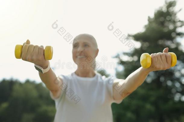 积极的有思想的退休的女人训练和重量