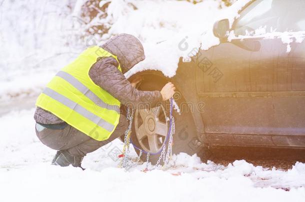 男人安装雪链向指已提到的人轮子关于汽车.