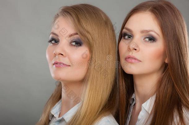 两个美丽的女人,白肤金发碧眼女人和黑头发的妇女使摆姿势
