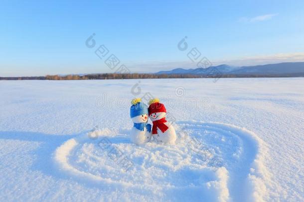幸福的对关于微笑的雪人.蓝色红色的帽子和围巾.描画的