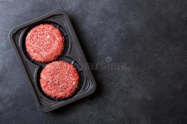 塑料制品盘子和生的切碎家使烧烤牛肉汉堡包和英文字母表的第19个字母