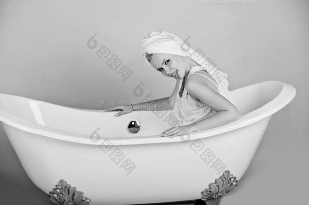 女人和毛巾长头巾一次采用白色的浴缸