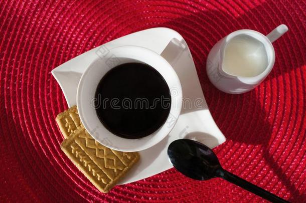 白色的杯子和咖啡豆向白色的正方形盘子,和det.一些甜饼干.