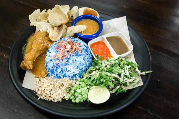 <strong>米饭</strong>凯拉布和鸡和cordiments是（be的三单形式流行的马来人食物