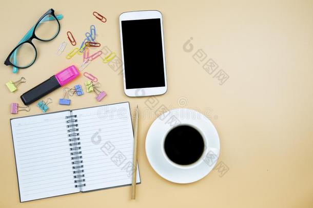 笔记簿可移动的电话计算器和黑的咖啡豆白色的杯子蓝色