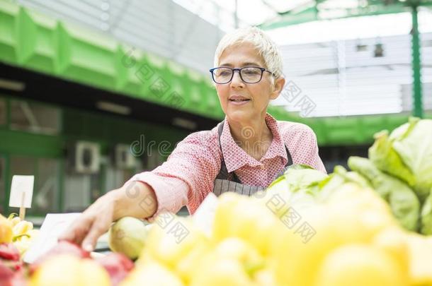 较高的女人卖蔬菜向交易