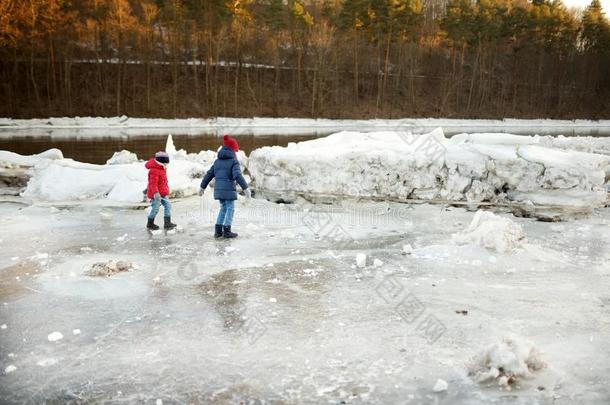 两个幸福的姐演奏和冰赛跑者起跑时脚底所撑的木块在旁边冷冻的河在的时候