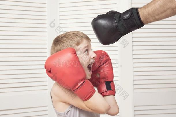 男孩采用box采用g拳击手套战斗和一m一n`英文字母表的第19个字母h一nd采用一手套.